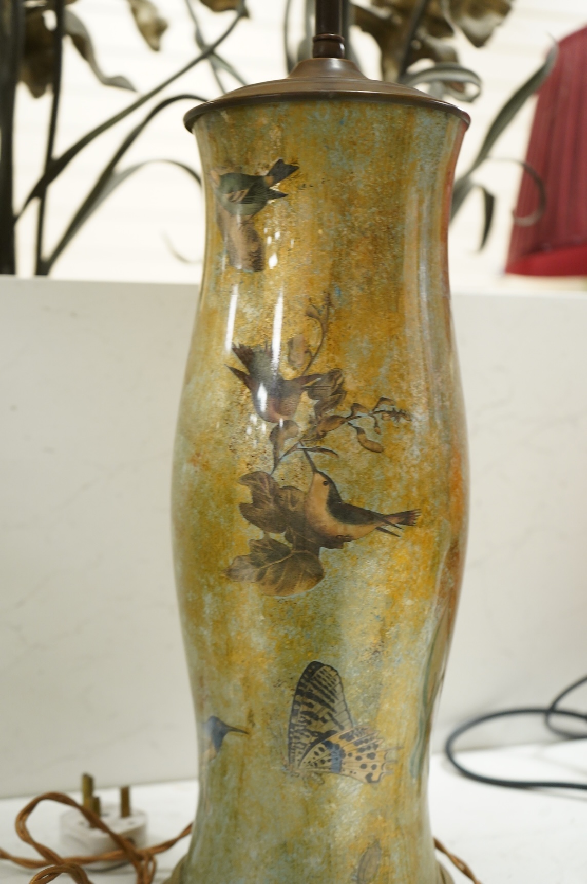 A pair of table lamps and shades, 92cm high, the lamps decorated in gold and green tones painted with birds and flowers, together with a small glass and brass hall lantern (3).